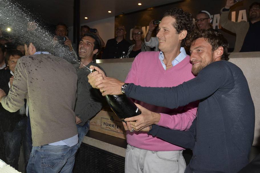 Claudio Marchisio aiuta John Elkann a stappare lo champagne. LaPresse